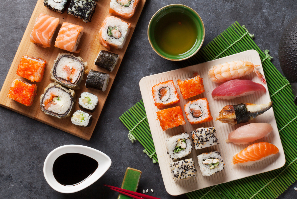 Set of sushi and maki roll and green tea on stone table. Top view