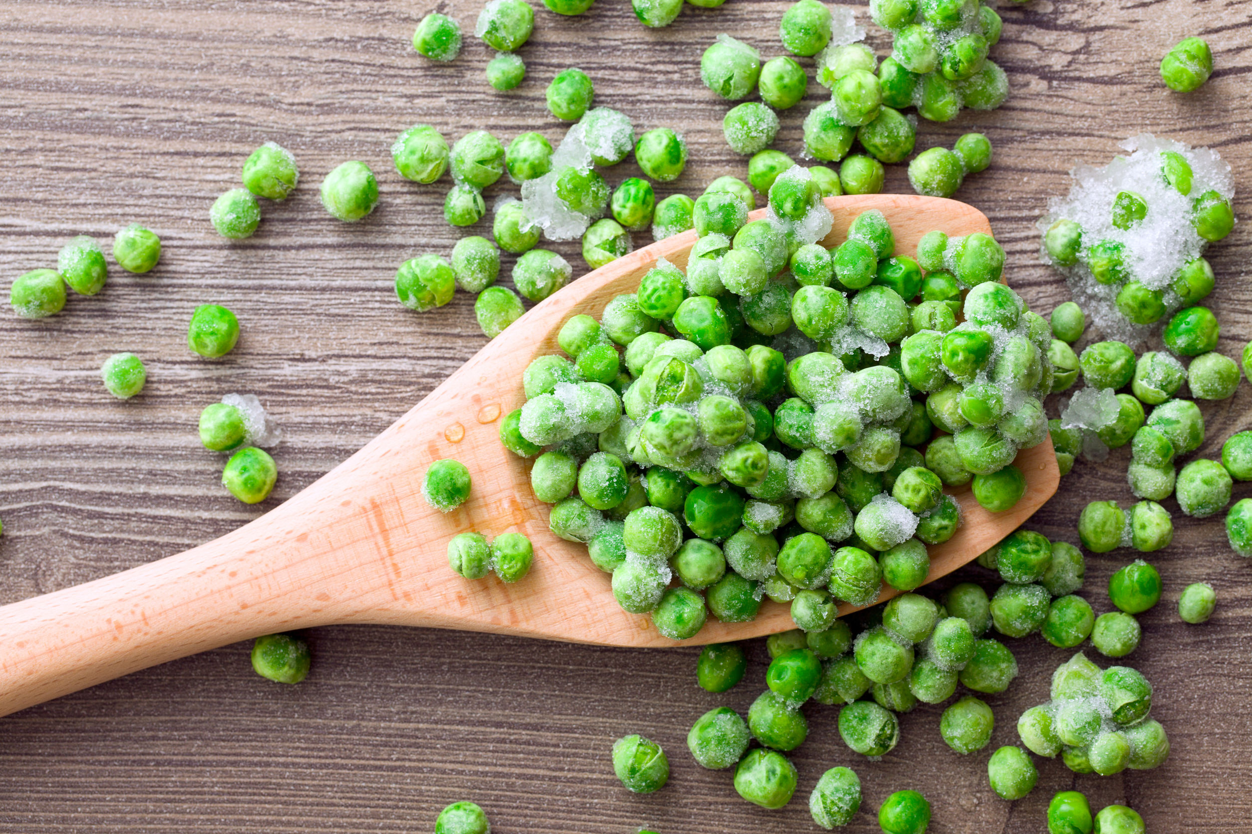 frozen peas on a wooden spoon